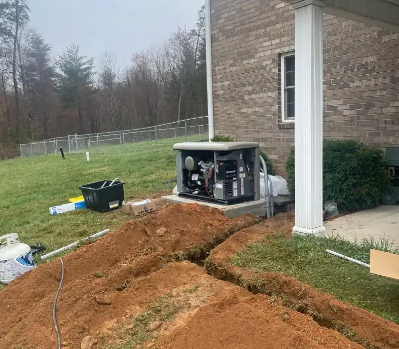 A standby generator is installed next to a brick house, with exposed wiring and freshly dug trenches in the yard—evidence of ongoing work by a pre-eminent electrical service company in Alamance County, NC. Tools and boxes are scattered nearby.