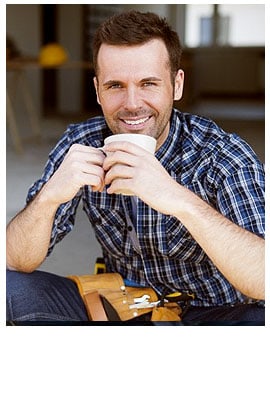 A smiling man in a plaid shirt sits and holds a cup of coffee. With short brown hair and a tool belt around his waist, he looks like he&rsquo;s taking a break from work at NC&rsquo;s pre-eminent electrical service company in Alamance County.